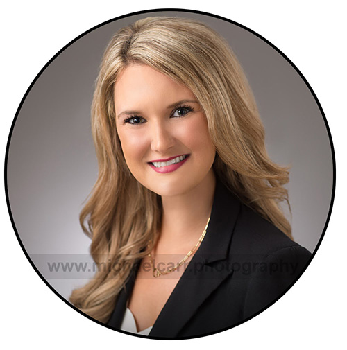 Professional woman’s headshot cropped for LinkedIn against a gradient gray background.
