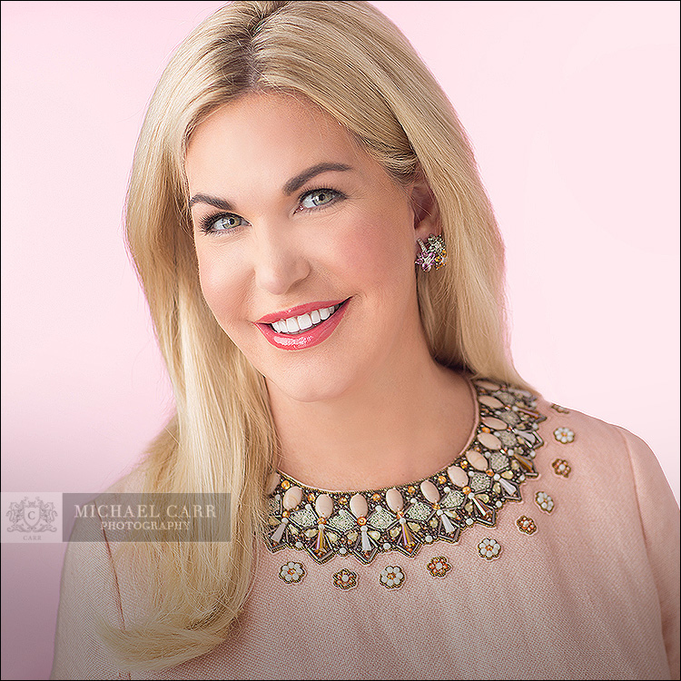 Modern executive headshot of a Houston business professional wearing a light pink blouse in Michael Carr Photography's studio.