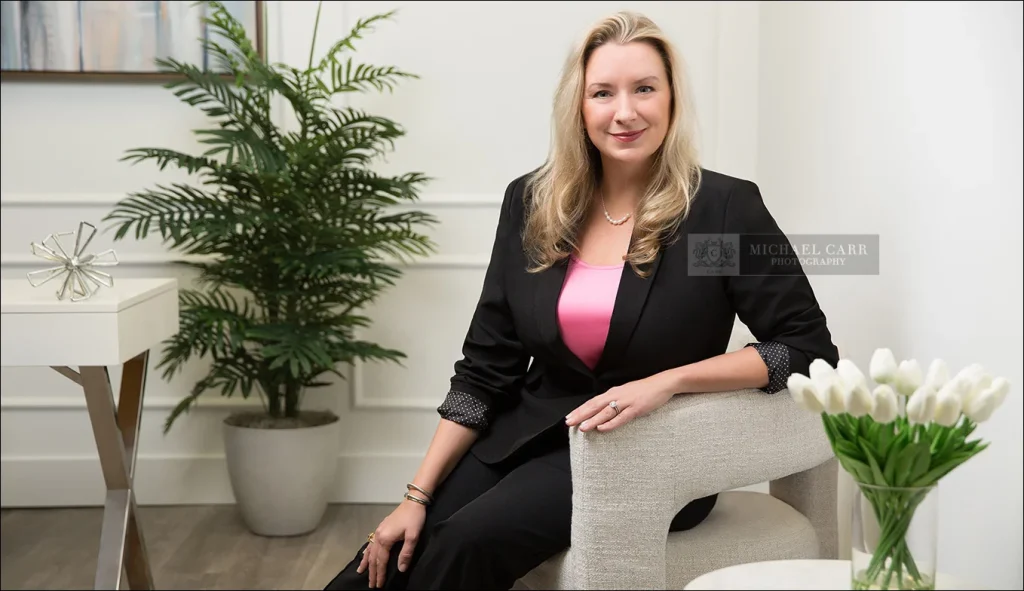 Modern executive headshot of a Houston business professional wearing a light pink blouse in Michael Carr Photography's studio.