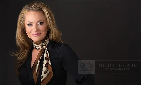 Houston executive headshots featuring a woman modern professional portrait with a black background and business attire.
