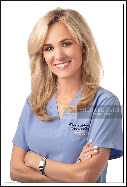 Professional executive headshot of a female physician wearing medical scrubs in a Houston photography studio.