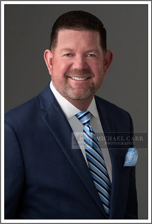 Classic corporate headshot of Houston business professional in navy suit