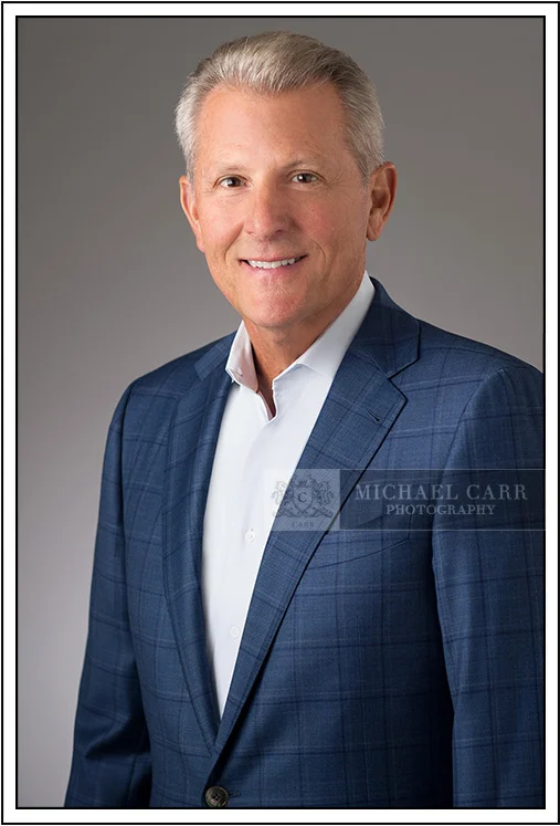 Houston Headshot Photographer Executive business headshot of a man in a blue suit photographed in a Houston studio