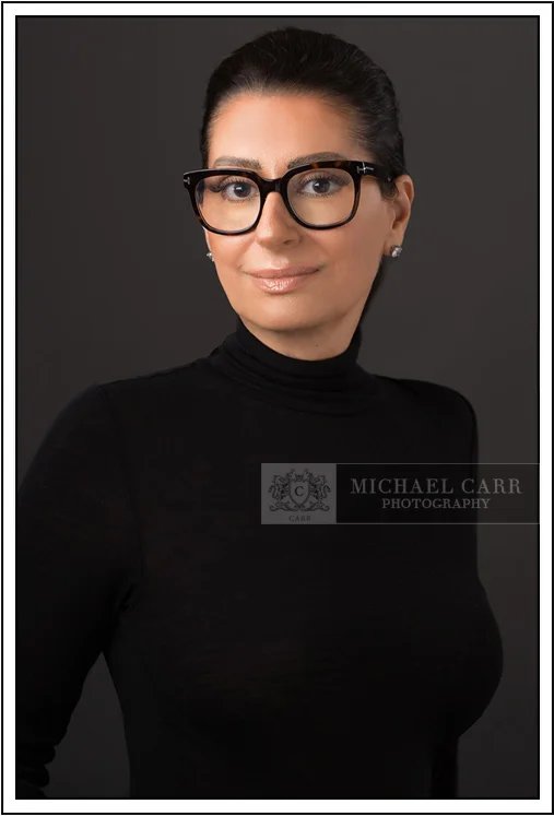 Houston Headshot Photographer Modern Houston corporate headshot of a female business professional wearing black attire and eyeglasses.