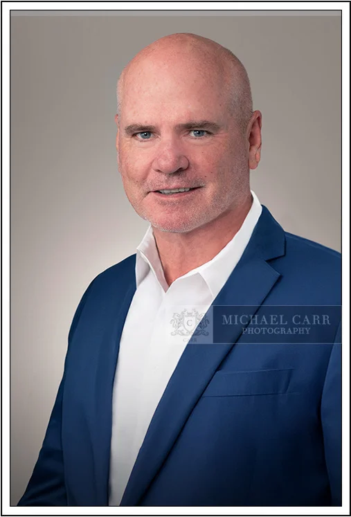 Houston Headshot Photographer Houston on-location executive headshot of man in blue jacket
