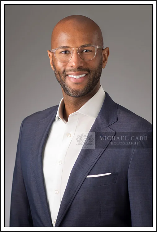 Houston Headshot Photographer Professional executive headshot of a man in a navy suit photographed in a Houston studio